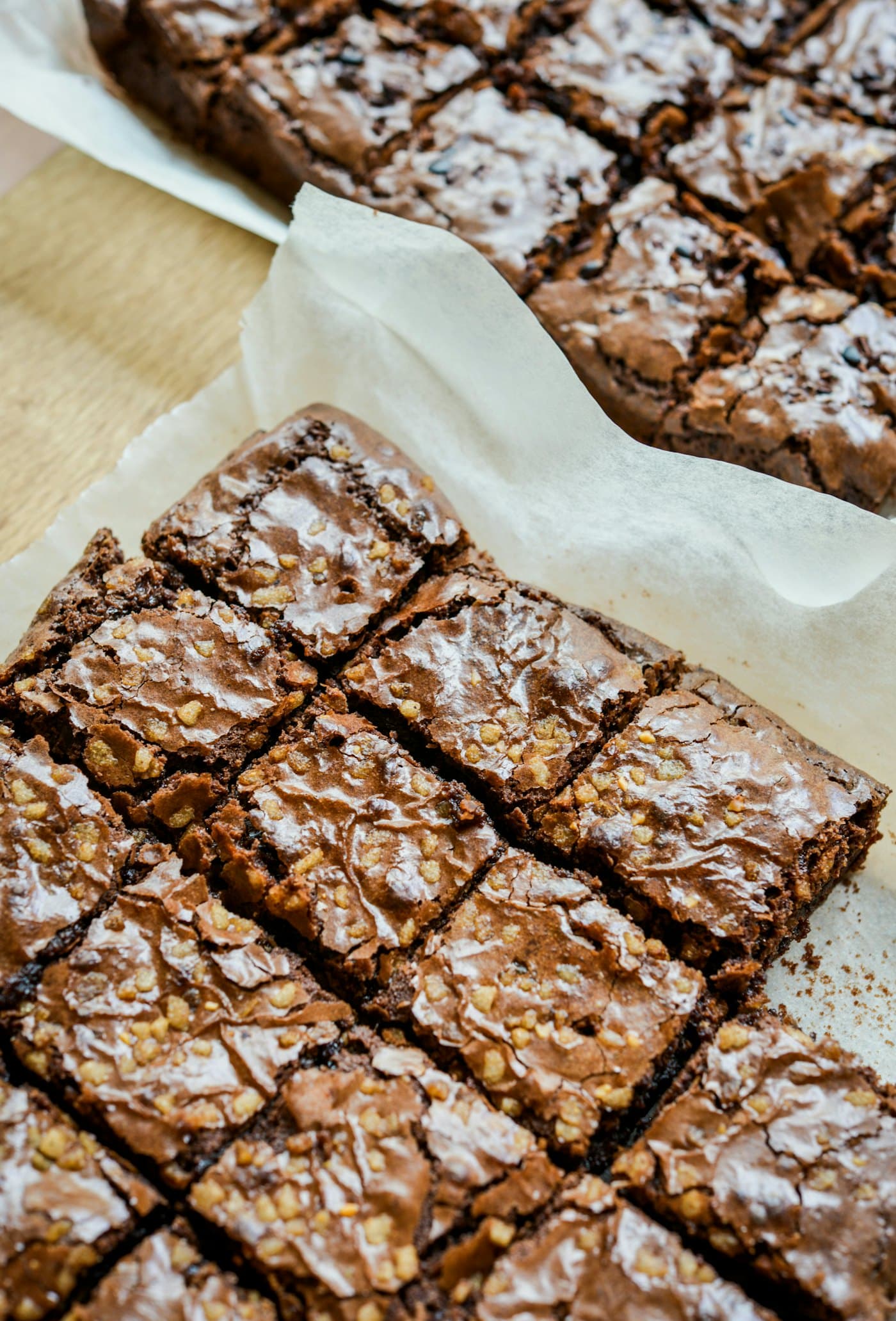 A tray of brownies cut into squares on baking paper