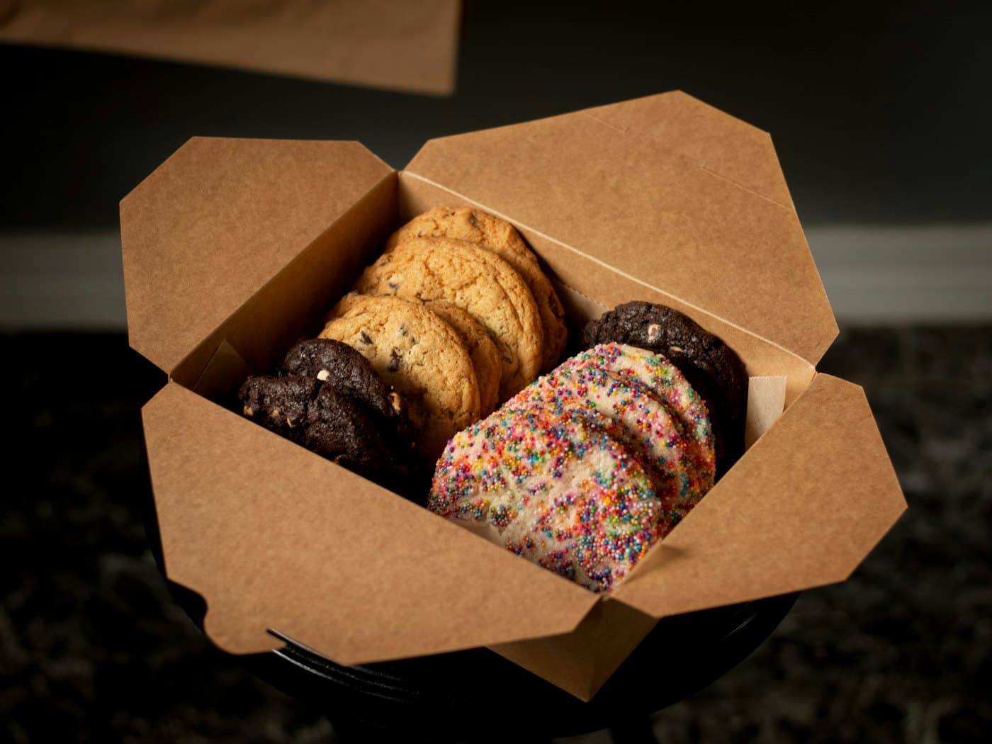 An open kraft box filled with cookies and brownies